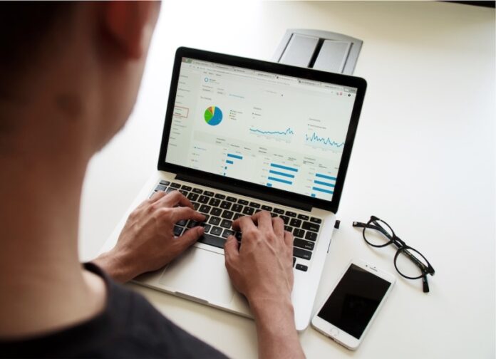 Person using laptop to look up data analytics to create a node diagram